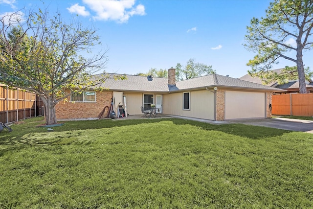 back of house with a lawn, a garage, and a patio