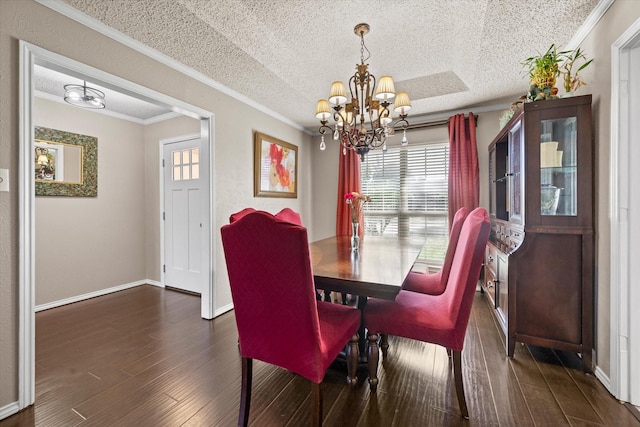 dining space featuring dark hardwood / wood-style flooring, ornamental molding, a textured ceiling, and an inviting chandelier