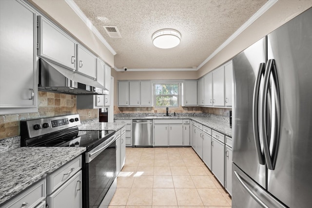 kitchen featuring appliances with stainless steel finishes, a textured ceiling, light tile patterned floors, and sink