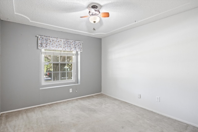 carpeted spare room featuring ceiling fan and a textured ceiling