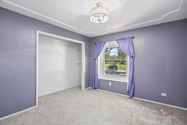 unfurnished bedroom featuring carpet flooring, a closet, and a textured ceiling