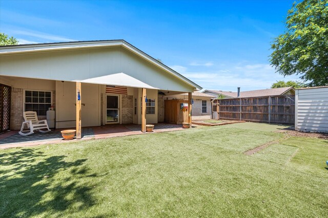 back of house featuring a lawn and a patio