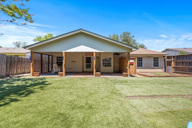 back of house featuring a patio area and a lawn