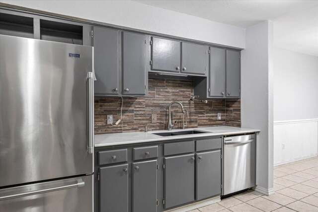 kitchen with gray cabinetry, sink, and appliances with stainless steel finishes