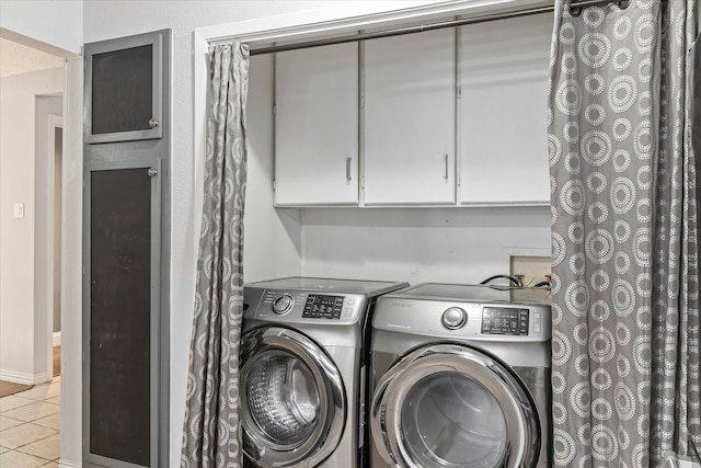 clothes washing area featuring washer and clothes dryer and light tile patterned flooring