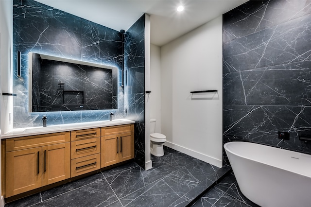 bathroom featuring vanity, toilet, a bathtub, and tile walls