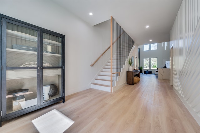 foyer entrance featuring light wood-type flooring and a high ceiling