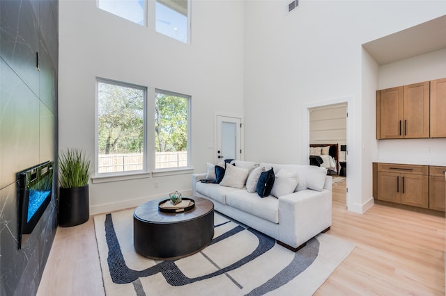 living room featuring light hardwood / wood-style floors and a towering ceiling