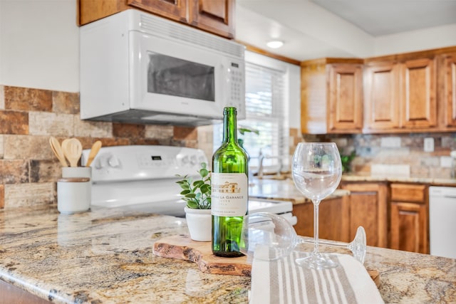 kitchen with light stone counters and white appliances