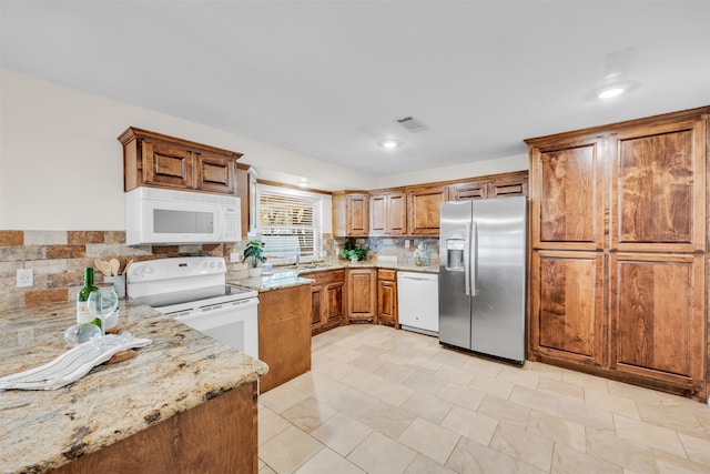 kitchen featuring backsplash, light stone counters, white appliances, sink, and light tile patterned flooring