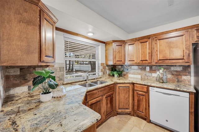 kitchen featuring dishwasher, light stone countertops, sink, and tasteful backsplash