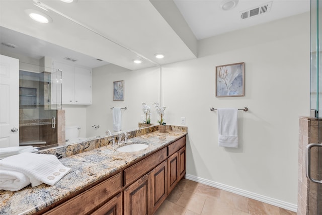 bathroom featuring tile patterned floors, vanity, toilet, and walk in shower