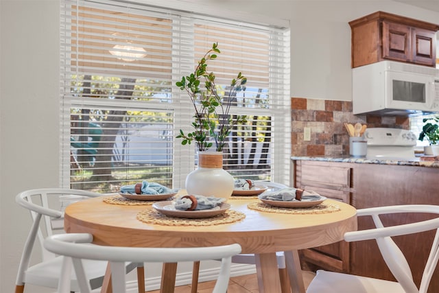 dining space with light tile patterned floors and a healthy amount of sunlight