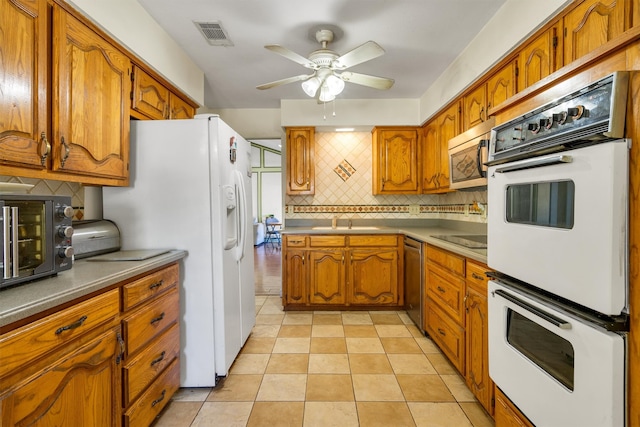 kitchen featuring decorative backsplash, appliances with stainless steel finishes, ceiling fan, sink, and light tile patterned floors