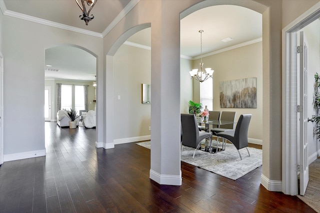 dining space featuring crown molding, dark hardwood / wood-style floors, and an inviting chandelier