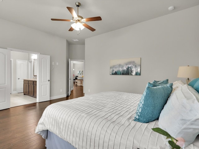 bedroom with ceiling fan, dark wood-type flooring, and connected bathroom