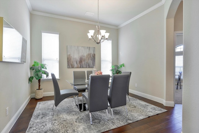 dining space featuring ornamental molding, dark wood-type flooring, and a chandelier