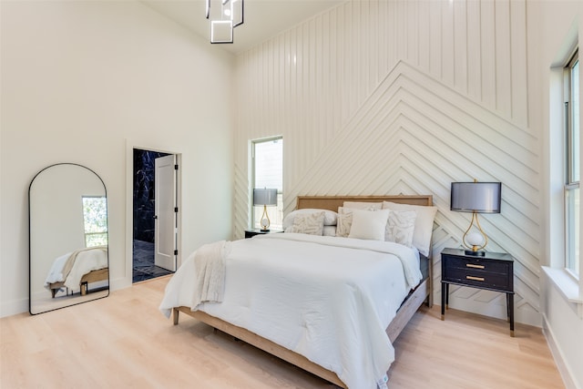 bedroom with light hardwood / wood-style floors and multiple windows