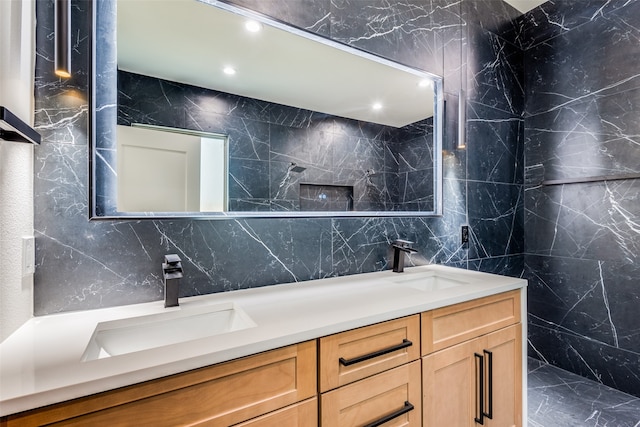 bathroom with vanity, tile walls, and a shower