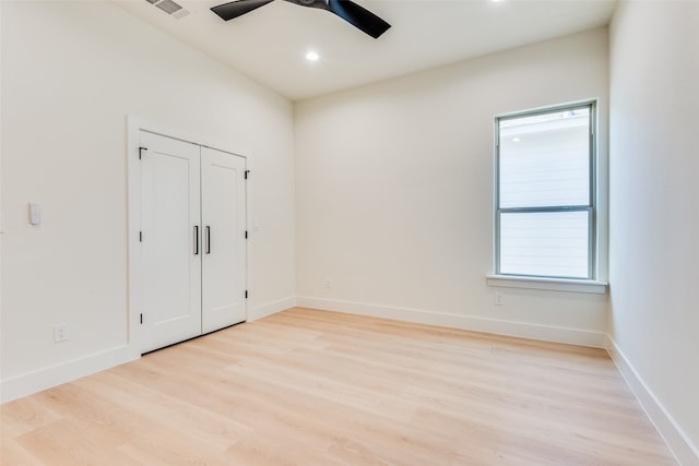 unfurnished bedroom featuring ceiling fan, light hardwood / wood-style floors, and a closet