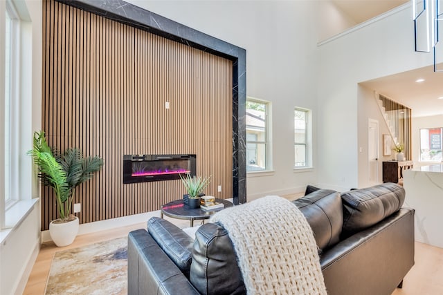 living room featuring a towering ceiling and light hardwood / wood-style flooring