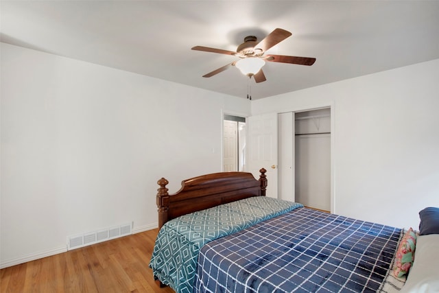 bedroom with ceiling fan, a closet, and wood-type flooring