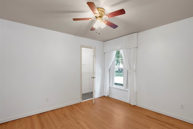 empty room with ceiling fan and light hardwood / wood-style flooring