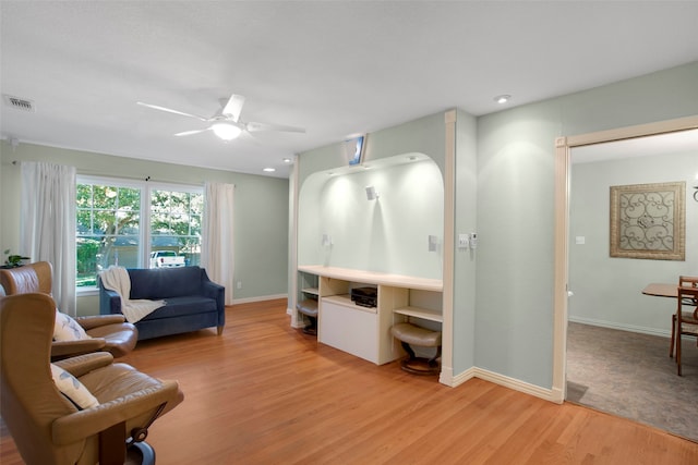 living room featuring ceiling fan and light hardwood / wood-style flooring