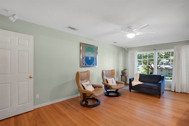 living area with ceiling fan and light hardwood / wood-style floors