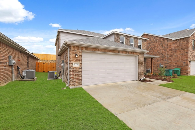 view of front of home with a garage, central AC, and a front lawn