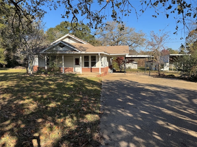 view of front of home with a carport and a front lawn