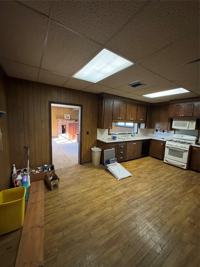 kitchen with sink, light hardwood / wood-style floors, white appliances, a paneled ceiling, and dark brown cabinets