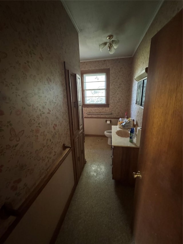 bathroom with vanity, toilet, and crown molding