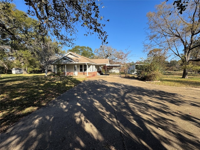 view of front of home featuring covered porch and a front lawn