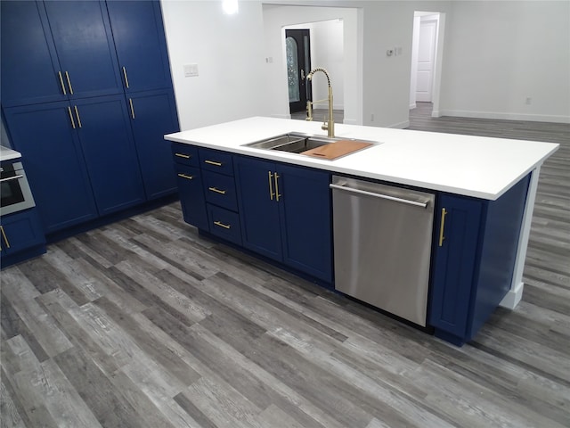 kitchen with blue cabinetry, a kitchen island with sink, sink, and stainless steel dishwasher