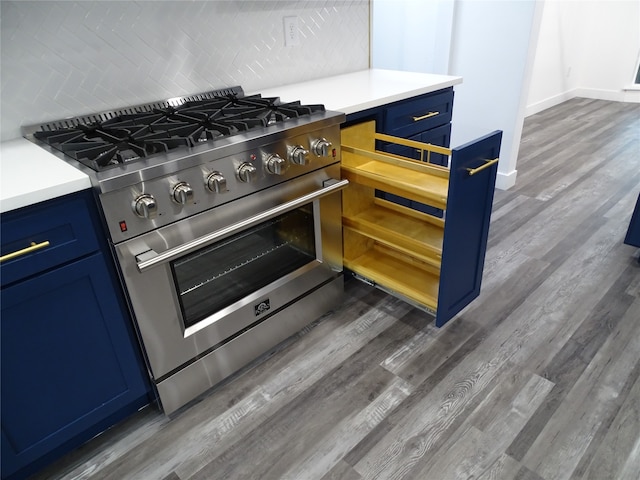 kitchen with stainless steel stove, blue cabinets, and dark wood-type flooring