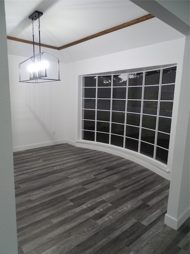 unfurnished dining area featuring dark hardwood / wood-style flooring, crown molding, and a notable chandelier