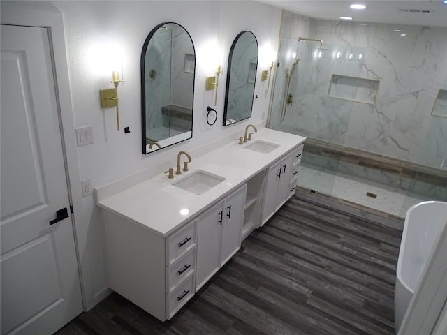 bathroom with tiled shower, vanity, and hardwood / wood-style flooring