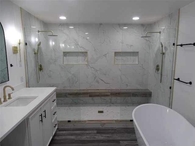 bathroom with hardwood / wood-style floors, vanity, and independent shower and bath