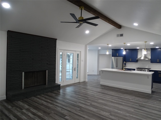 unfurnished living room featuring sink, a brick fireplace, ceiling fan, beamed ceiling, and dark hardwood / wood-style flooring