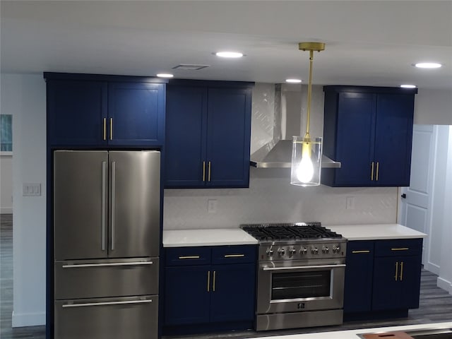 kitchen featuring appliances with stainless steel finishes, blue cabinets, and wall chimney range hood