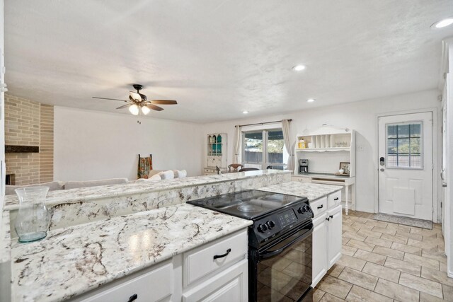 kitchen featuring electric range, ceiling fan, light stone counters, and white cabinetry