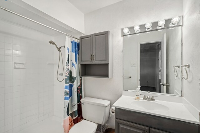 bathroom with walk in shower, vanity, and toilet