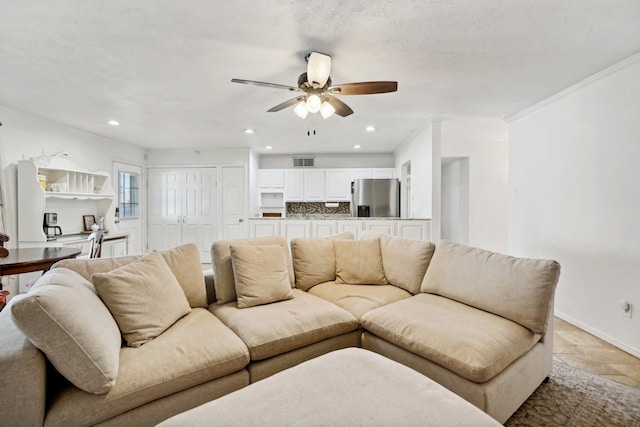 living room featuring a textured ceiling, ceiling fan, and crown molding