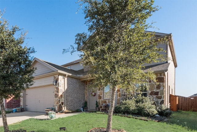 view of property hidden behind natural elements with a garage and a front yard