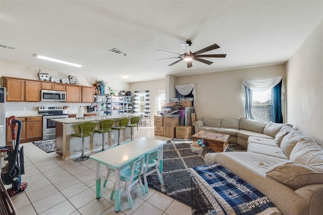 tiled living room with ceiling fan