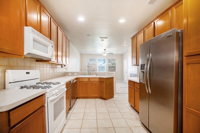 kitchen featuring kitchen peninsula, appliances with stainless steel finishes, backsplash, ceiling fan, and light tile patterned floors