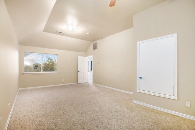 carpeted spare room featuring ceiling fan and lofted ceiling