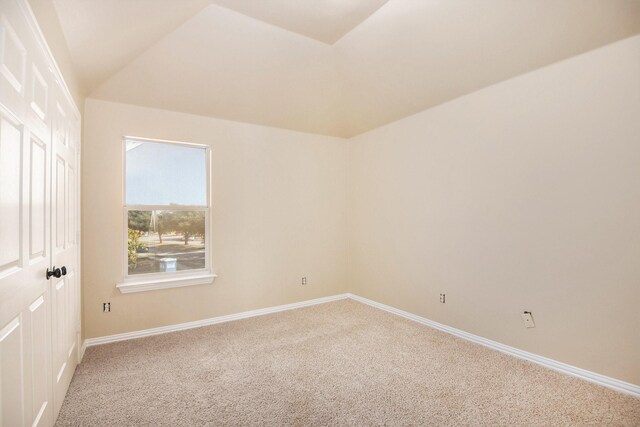 empty room featuring carpet floors and lofted ceiling