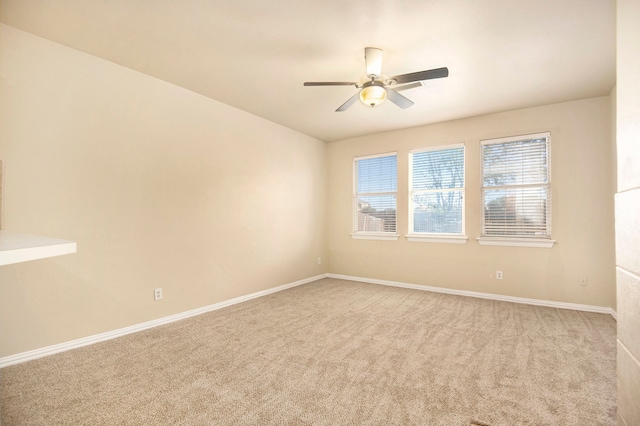 spare room with ceiling fan and light carpet